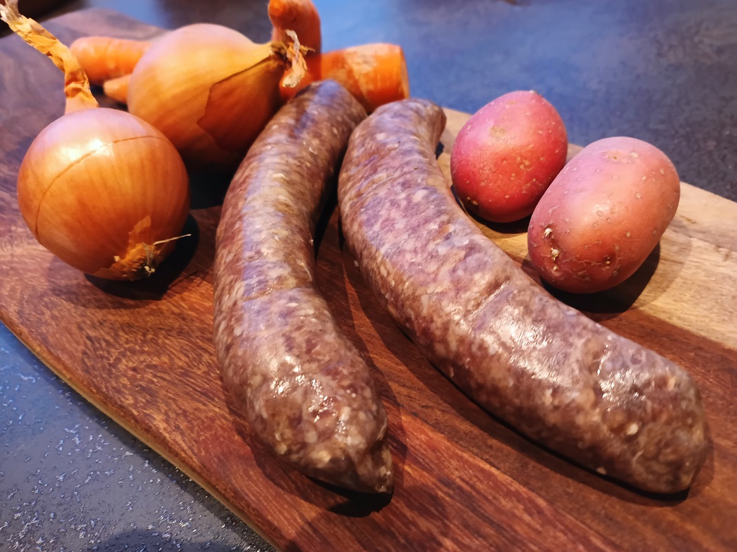 Rundersaucijsen op plank met uien en aardappels Vleesch van de weij