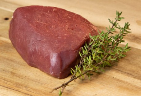 Biefstuk van de haas met takje tijm op een plank Vleesch van de weij