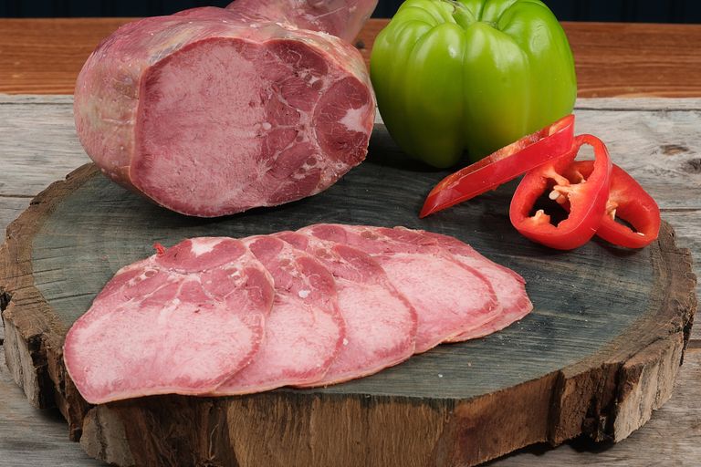 gekookte en gesneden rundertong op een plank met paprika