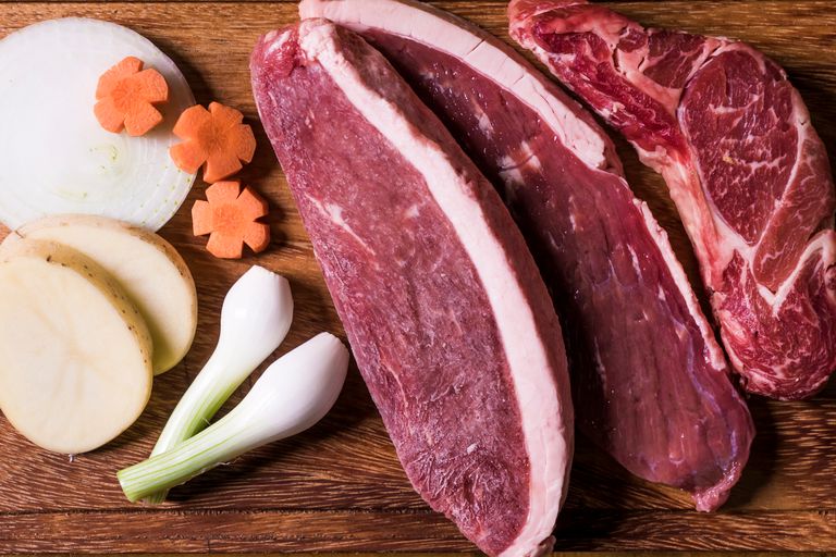 Picanha op een houten bord met groenten